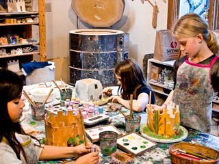 Glazing Castles Three girls applying underglaze to their clay castle sculptures